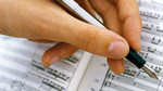 Click here to listen to Settling the Score. Image: Someone marking up a musical score.